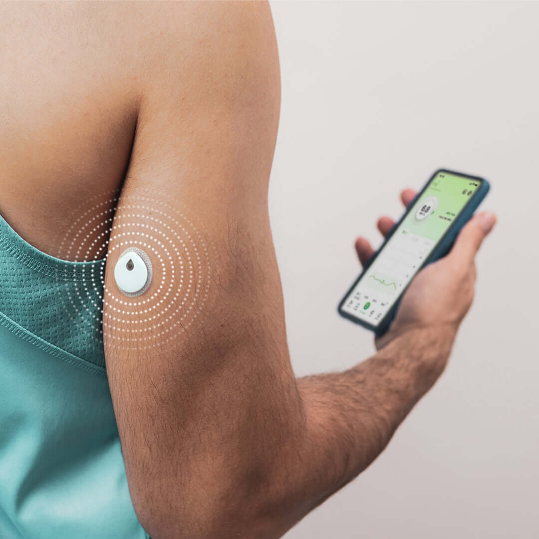Person using LinX Vista Continuous Glucose Monitoring System sensor on arm with mobile app displaying glucose data.